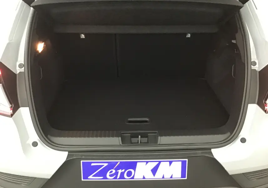 Coffre ouvert vu de l'arrière d'un Renault Captur 2025 gris Rafale avec intérieur noir et éclairage latéral allumé.