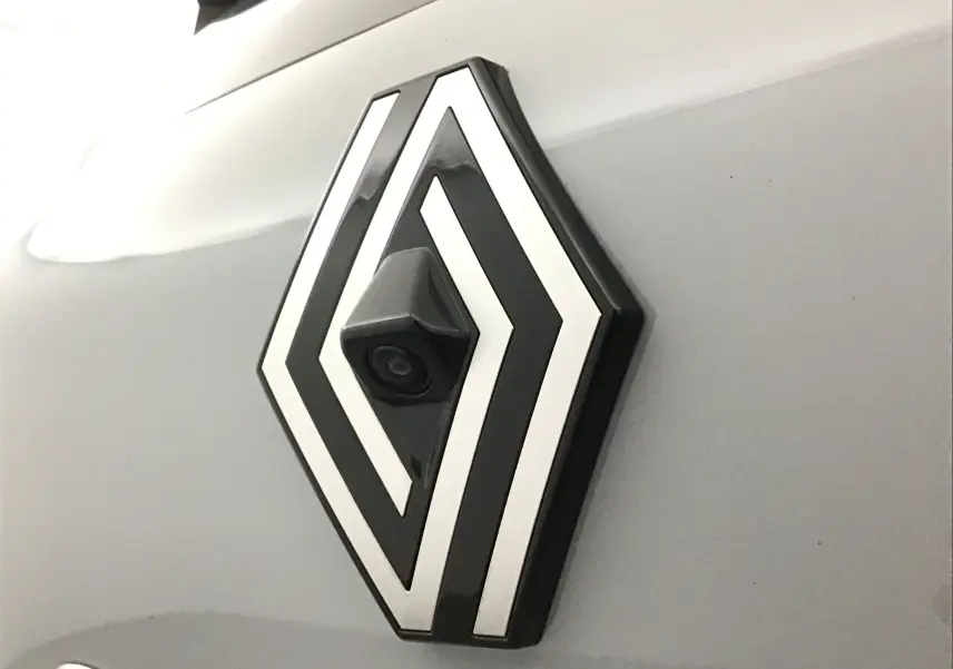Gros plan sur le logo Renault gris rafale avec caméra de recul intégrée sur le hayon arrière du Captur 2025.