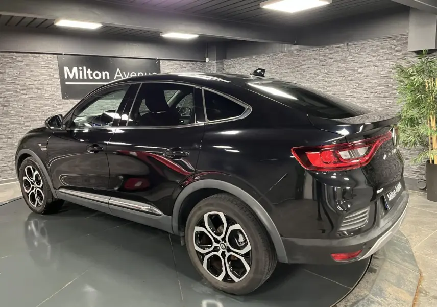 Vue 3/4 arrière droite d'une Renault Arkana noire avec jantes alliage noires et feux arrière LED distinctifs.