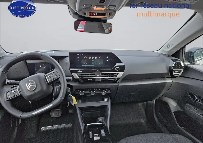 Vue intérieure avant de la Citroën C4 blanche, tableau de bord avec écran tactile et volant multifonction noir.