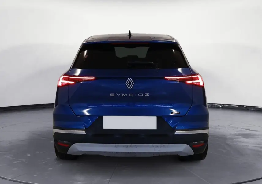 Vue arrière du Renault SYMBIOZ E-TECH Full Hybrid 145 Iconic 2025 en bleu iron avec feux LED fins allumés.