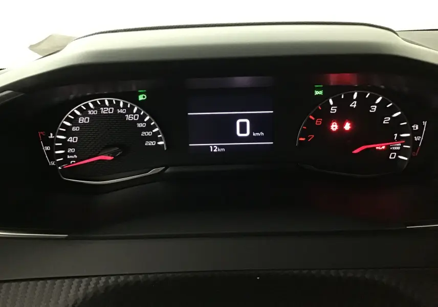 Tableau de bord du Peugeot 208 blanc 2024, affichage numérique au centre avec compteur vitesse et compte-tours éclairés.