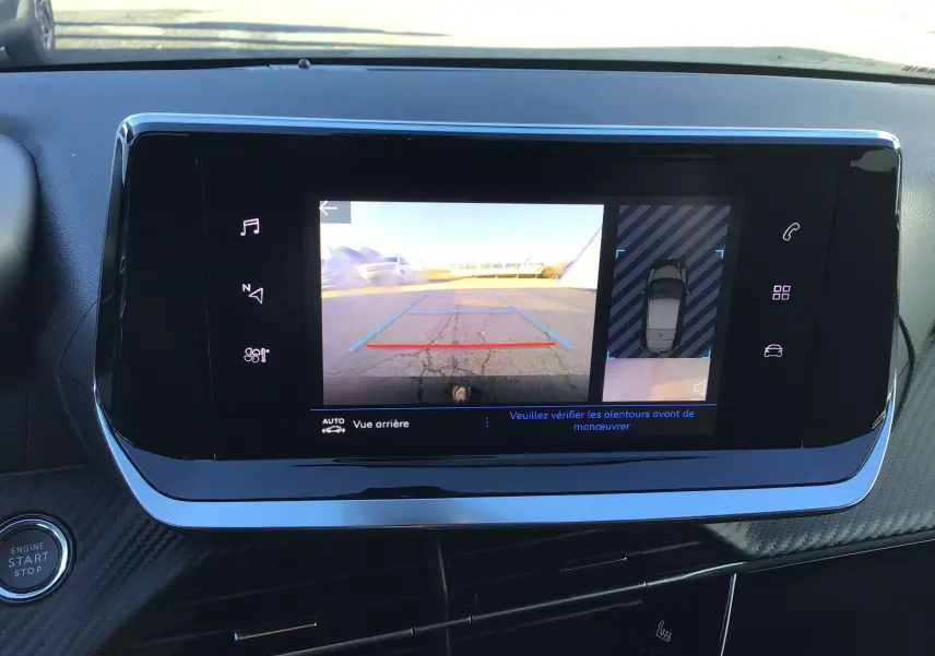 Écran tactile intérieur de la Peugeot 208 blanc 2024 affichant la caméra de recul et l'aide au stationnement.