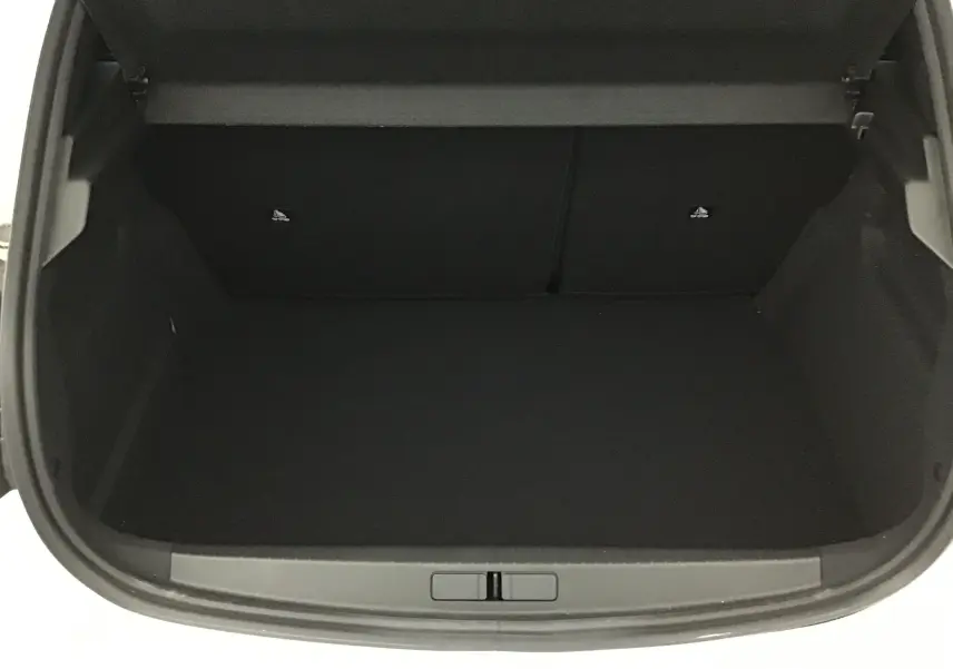 Coffre ouvert vu de dessus d'une Peugeot 208 blanche 2024, montrant un espace de chargement vide et propre.