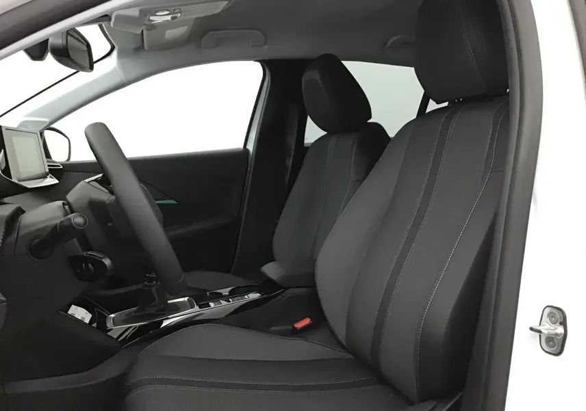 Vue intérieure côté conducteur d'une Peugeot 208 blanche 2024, sièges noirs avec surpiqûres grises et console centrale moderne.