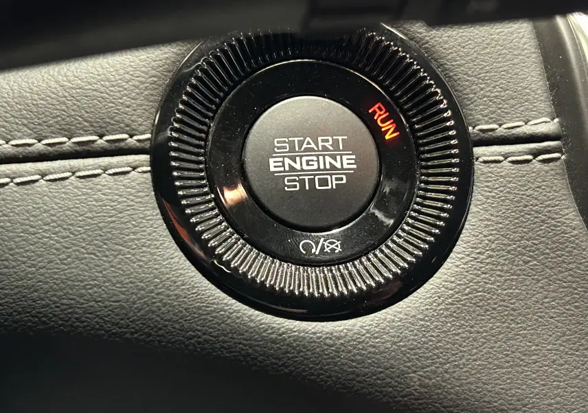 Gros plan sur le bouton Start Engine Stop noir avec indication RUN rouge, sur tableau de bord cuir gris du Jeep Compass 2021.