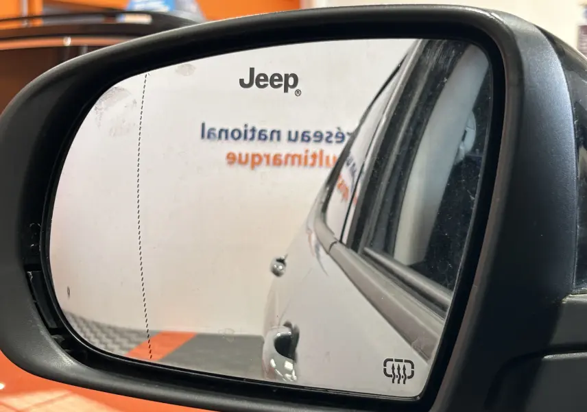 Rétroviseur gauche montrant le côté gris métallisé du Jeep Compass Limited 2021 avec logo Jeep visible sur le miroir.
