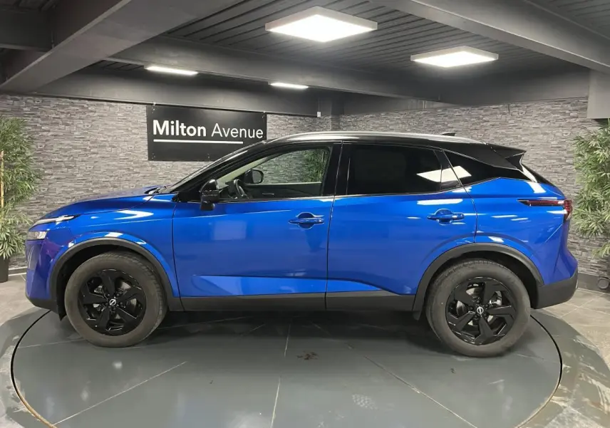 Vue de profil côté gauche d'un Nissan Qashqai 1.3 Mild Hybrid 140 Shadow bleu avec toit noir et jantes noires.