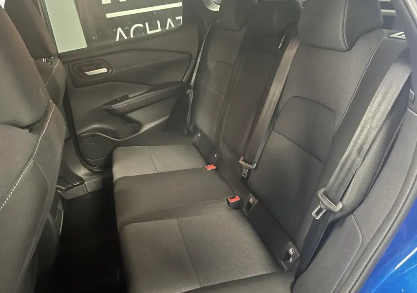 Vue intérieure de la banquette arrière noire du Nissan Qashqai 2024 bleu, avec ceintures et portes ouvertes côté droit.