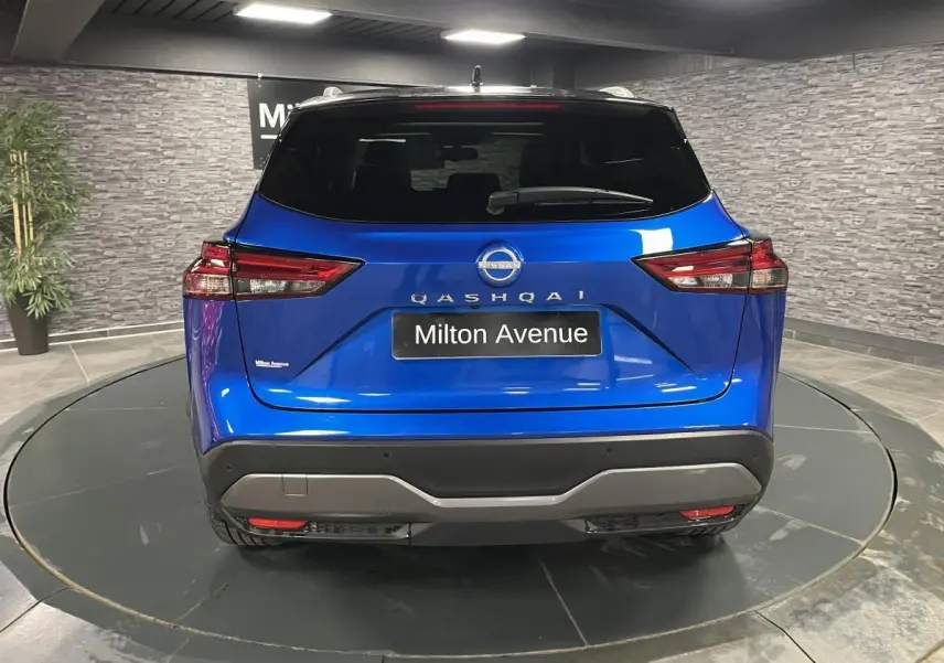 Vue arrière du Nissan Qashqai 1.3 Mild Hybrid 140 Shadow bleu avec feux LED et plaque Milton Avenue.