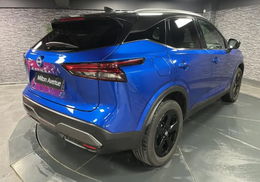 Vue 3/4 arrière droite du Nissan Qashqai 2024 bleu avec toit noir et jantes alliage noires spéciales.