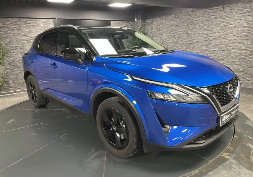 Nissan Qashqai 1.3 Mild Hybrid 2024 bleu, vue 3/4 avant droit avec jantes noires et toit noir.