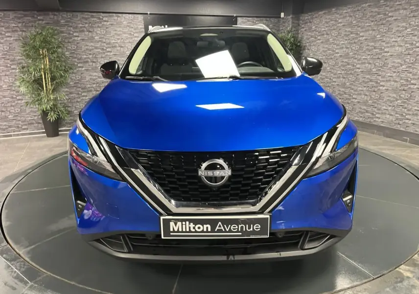 Vue avant d'un Nissan Qashqai 1.3 Mild Hybrid 140 Shadow bleu avec calandre noire et détails chromés.