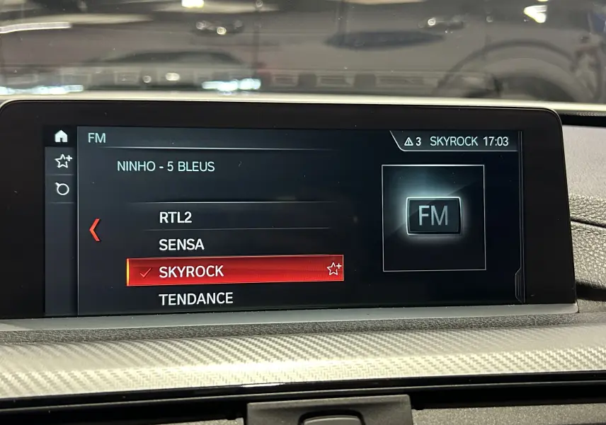Écran central de la BMW Série 3 320i 2018 montrant la sélection radio FM sur Skyrock avec interface moderne.