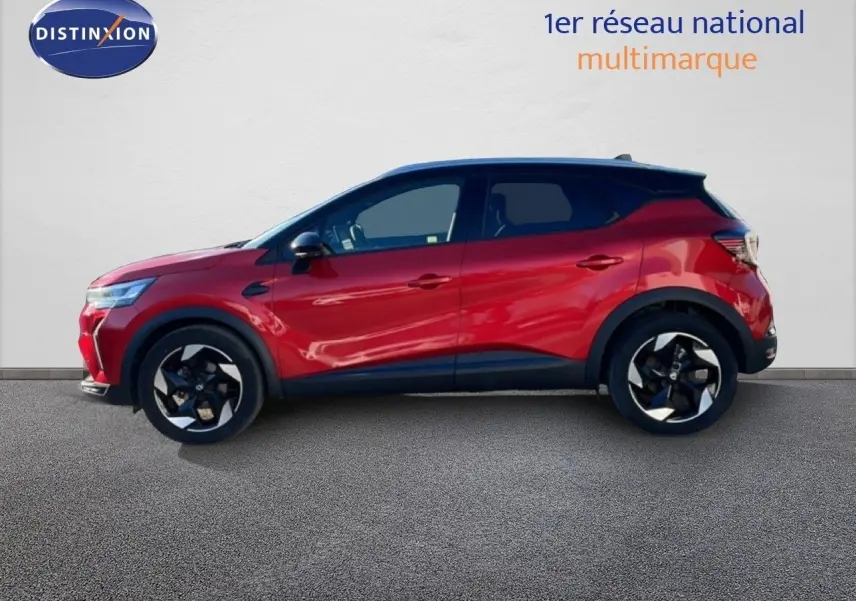 Profil droit du Renault Captur 2025 rouge désir métallisé avec toit noir, roues alliage bicolores et lignes dynamiques.