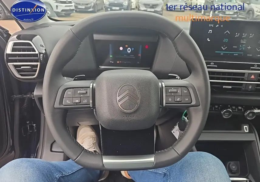 Vue intérieure centrée sur le volant cuir noir du Citroën C4 1.2 hybride 136 automatique avec tableau de bord numérique.