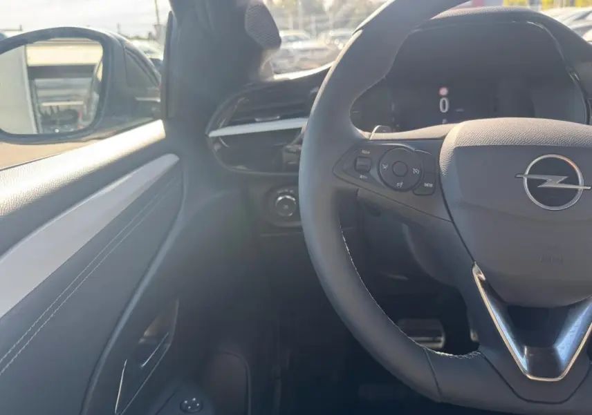 Vue intérieure côté conducteur de l’Opel Corsa rouge 2025, avec volant multifonction et tableau de bord digital.