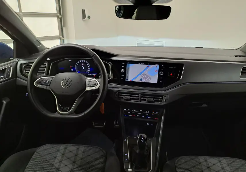 Vue intérieure avant de la Volkswagen Polo 1.0 TSI R-Line 2025, tableau de bord moderne avec écran tactile et volant multifonction.