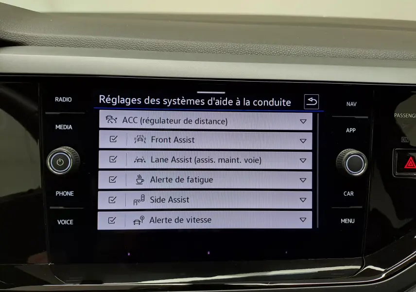 Écran tactile central affichant les réglages des aides à la conduite dans une Volkswagen Polo Bleu Récif.