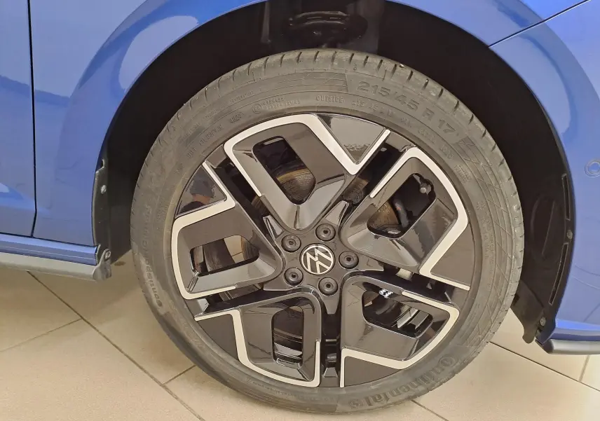Gros plan sur la roue avant droite d'une Volkswagen Polo Bleu Récif avec jante alliage noir et argentée R-Line.