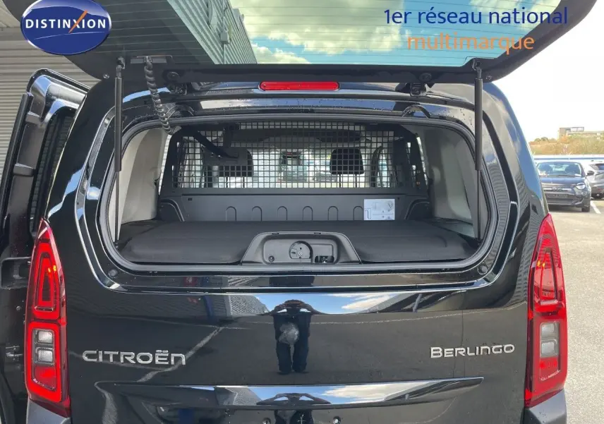 Vue arrière du Citroën Berlingo noir Perla Nera avec hayon ouvert et séparation intérieure métallique visible.