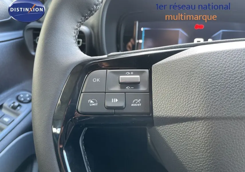 Gros plan sur le volant noir cuir du Citroën Berlingo 2026 avec commandes de régulateur et limiteur de vitesse.