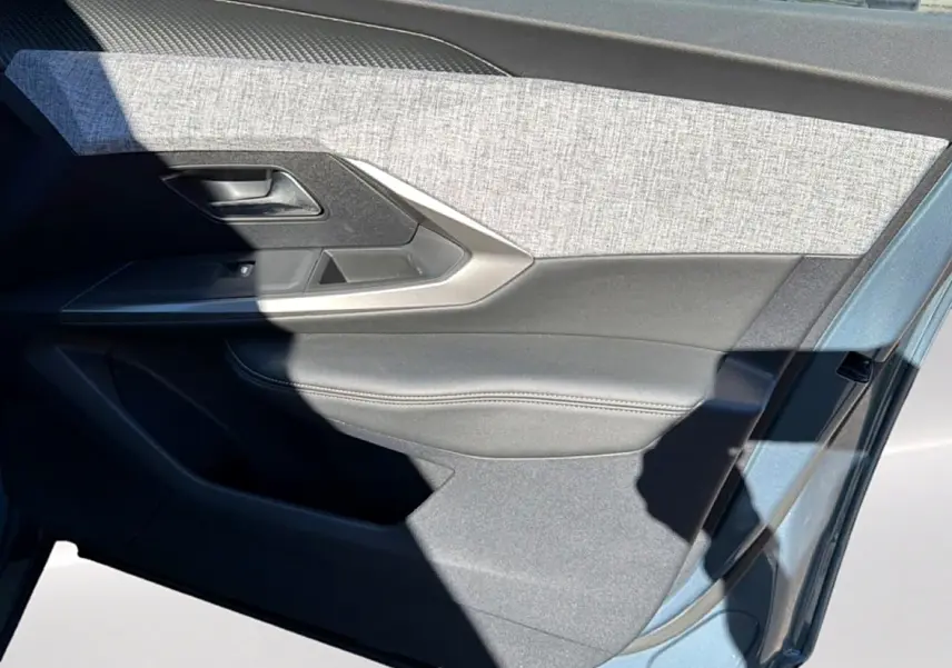 Vue rapprochée de la porte avant gauche du Peugeot 3008 2025 en Bleu Ingaro, avec habillage tissu et cuir gris.