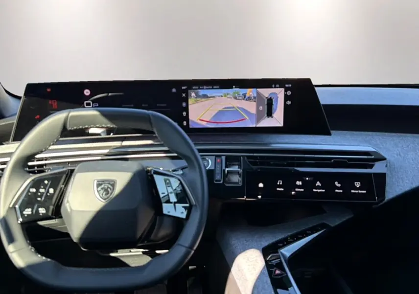 Vue intérieure centrée sur le volant cuir et l'écran tactile affichant la caméra de recul du Peugeot 3008.