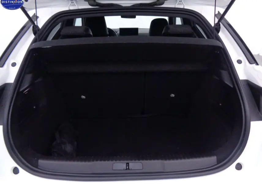 Coffre ouvert vu de l'arrière d'une DS3 Crossback blanc banquise, intérieur noir et banquette arrière visible.