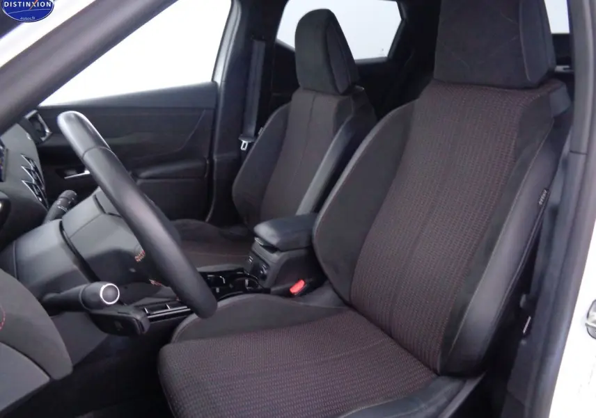 Vue intérieure côté gauche du DS3 Crossback blanc banquise, mettant en valeur les sièges avant en tissu noir avec surpiqûres rouges.