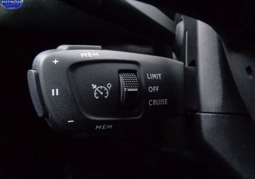 Gros plan sur la commande de régulateur de vitesse du DS3 Crossback blanc banquise, avec boutons MEM et sélecteur LIMIT/OFF/CRUISE.
