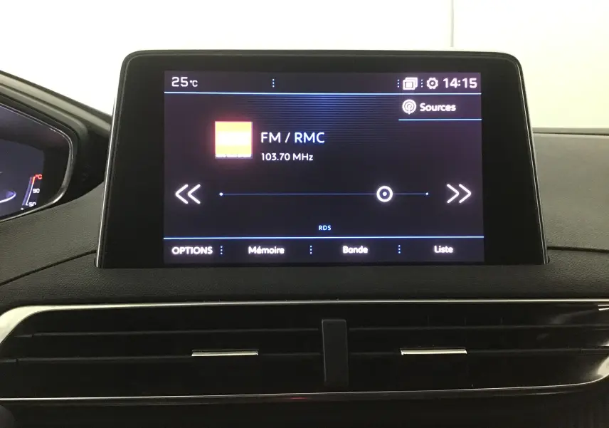 Écran central tactile du tableau de bord du Peugeot 5008 noir 2019 affichant la radio FM RMC à 103,7 MHz.