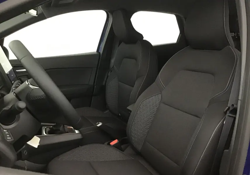 Vue intérieure côté conducteur du Renault Captur 2025 bleu iron/noir, sièges avant en tissu noir avec surpiqûres blanches.