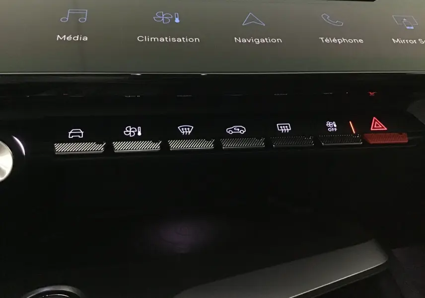 Vue rapprochée des commandes tactiles du tableau de bord de la Peugeot 308 gris Artense, avec éclairage des fonctions climatisation et sécurité.