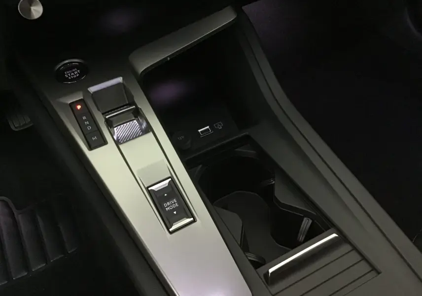 Console centrale de la Peugeot 308 gris Artense montrant la commande de boîte auto et le bouton Drive Mode en gros plan.