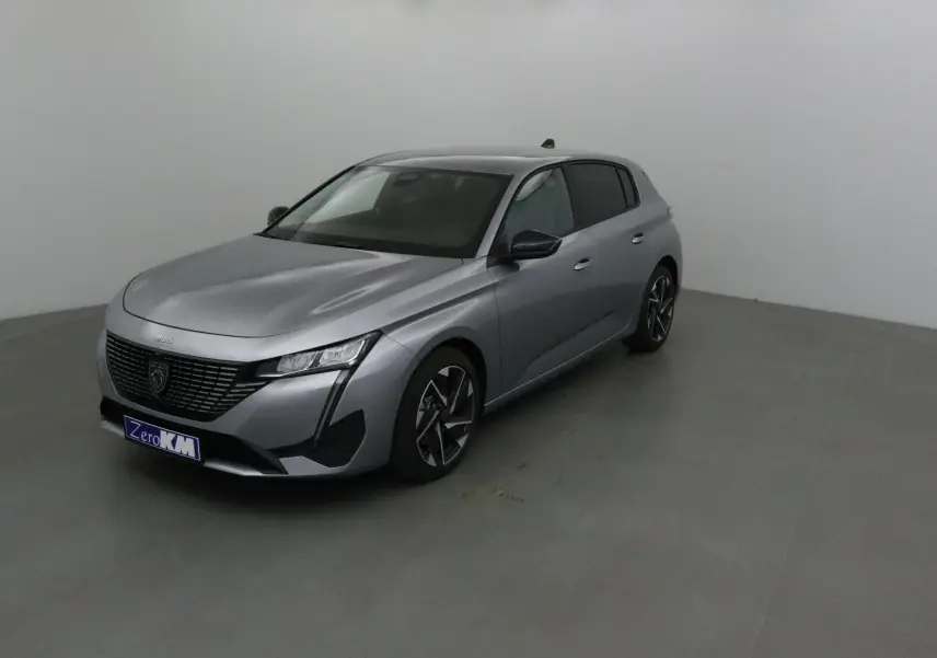 Peugeot 308 gris Artense vue 3/4 avant droit dans un studio, avec calandre noire et jantes alliage.