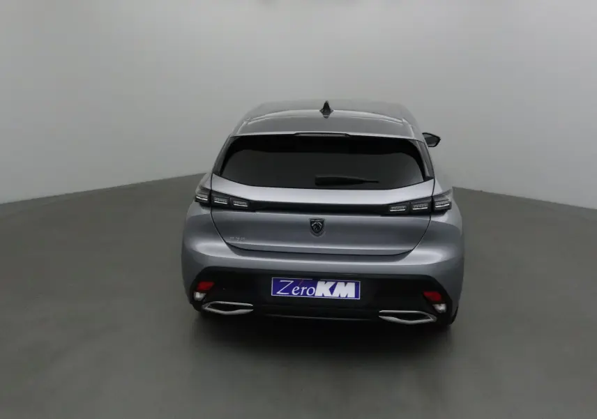 Vue arrière d'une Peugeot 308 gris Artense avec feux LED étirés et double sortie d'échappement chromée.