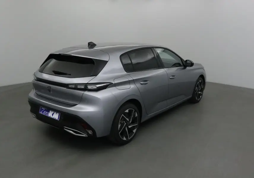 Peugeot 308 gris Artense vue 3/4 arrière droit dans un studio, avec vitres teintées et jantes alliage noires.