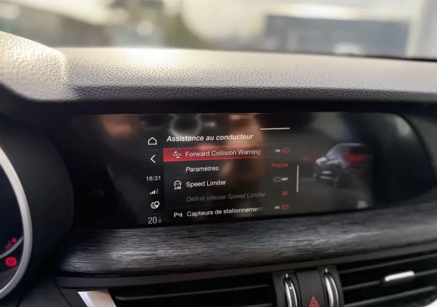 Écran central de l'Alfa Romeo Stelvio blanc 2023 affichant les options d'assistance au conducteur avec interface moderne.