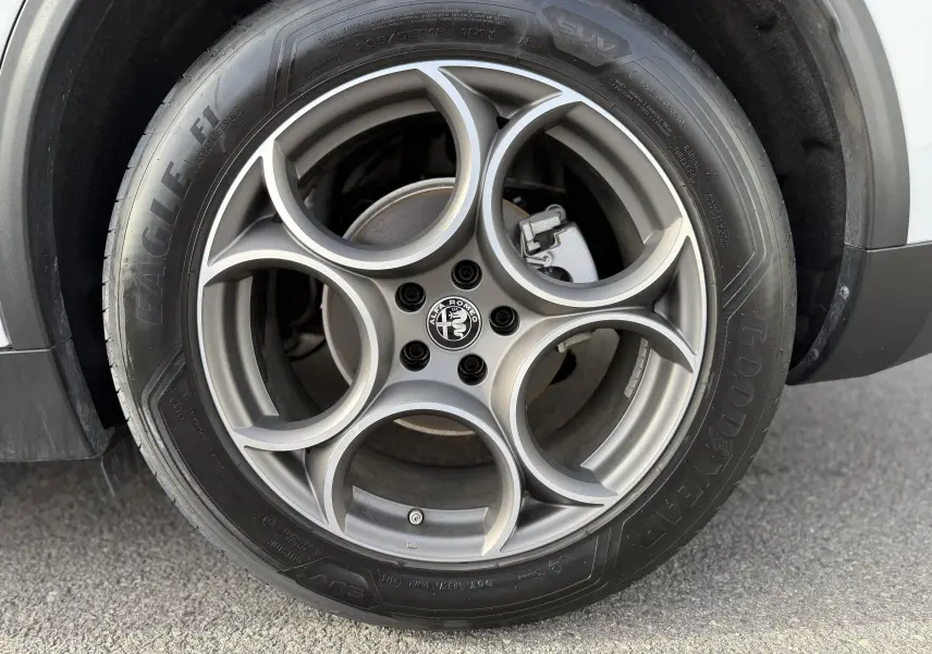 Gros plan sur la roue avant droite d'un Alfa Romeo Stelvio blanc Alfa 2023 avec pneu Goodyear Eagle.