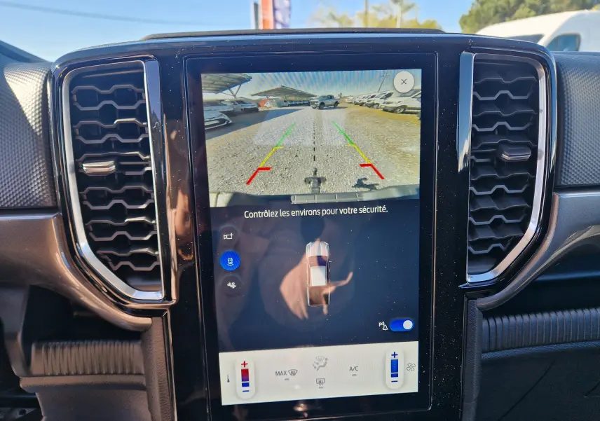 Écran tactile central du Ford Ranger Super Cabine gris Iconic 2026 montrant la caméra de recul et les commandes climatisation.