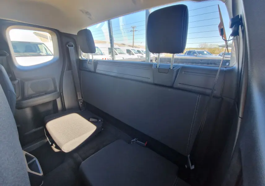 Vue intérieure arrière du Ford Ranger Super Cabine gris Iconic, montrant les sièges rabattables et appuie-têtes noirs.