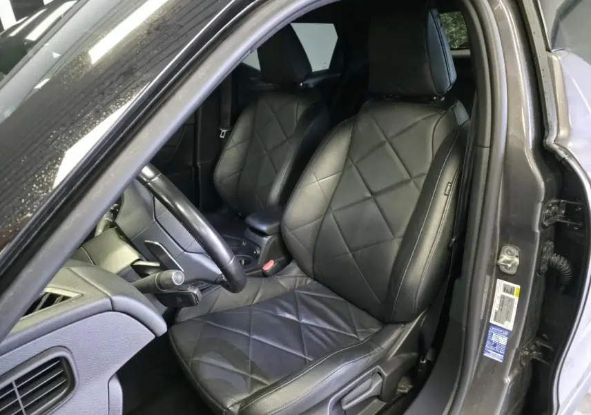 Vue intérieure côté conducteur du DS3 Crossback gris, mettant en valeur les sièges en cuir noir grainé et le volant cuir.