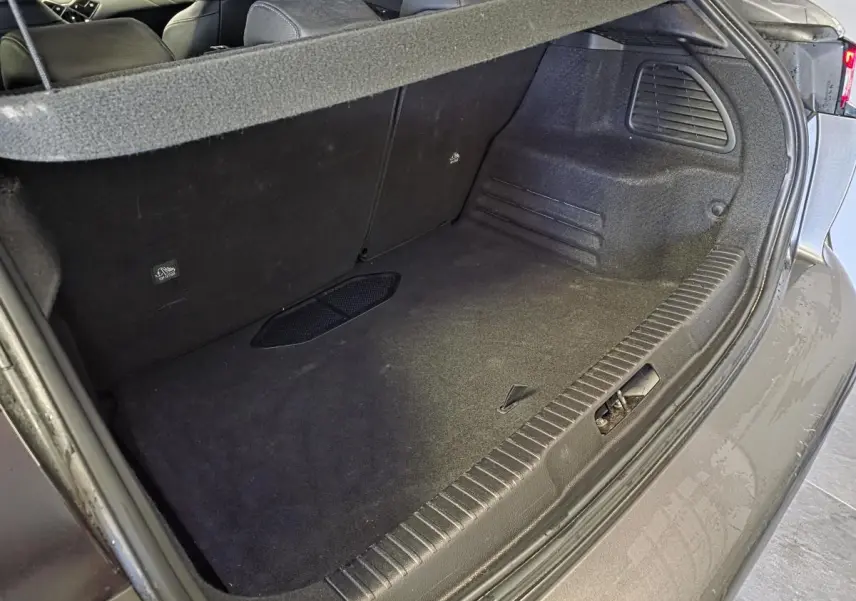 Coffre ouvert vu de trois quarts arrière droit du DS3 Crossback gris, montrant l'espace de chargement vide et les sièges arrière.