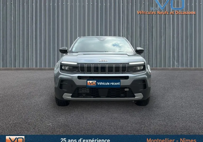 Vue frontale d'un Jeep Avenger gris foncé 2024 avec calandre distinctive et phares LED intégrés.