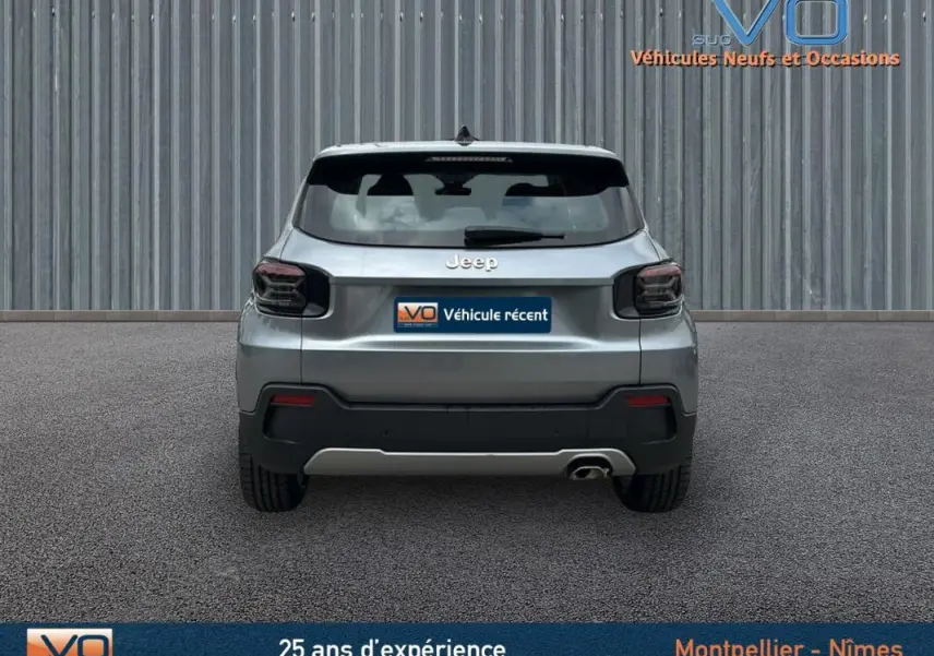 Vue arrière d'un Jeep Avenger gris foncé 2024 avec feux arrière fumés et une sortie d'échappement visible côté droit.