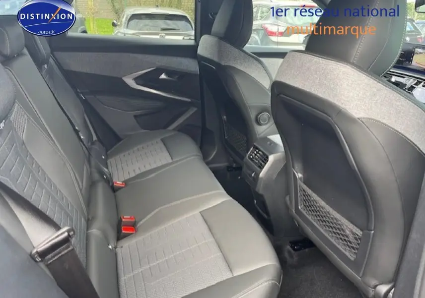 Vue intérieure arrière du Peugeot 3008 gris titane, montrant les sièges et les dossiers avant avec rangements filet.