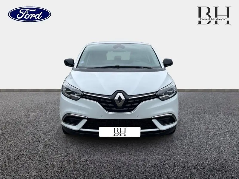 Vue de face d'une Renault Scénic blanc nacré 2022 avec calandre noire et phares LED intégrés.