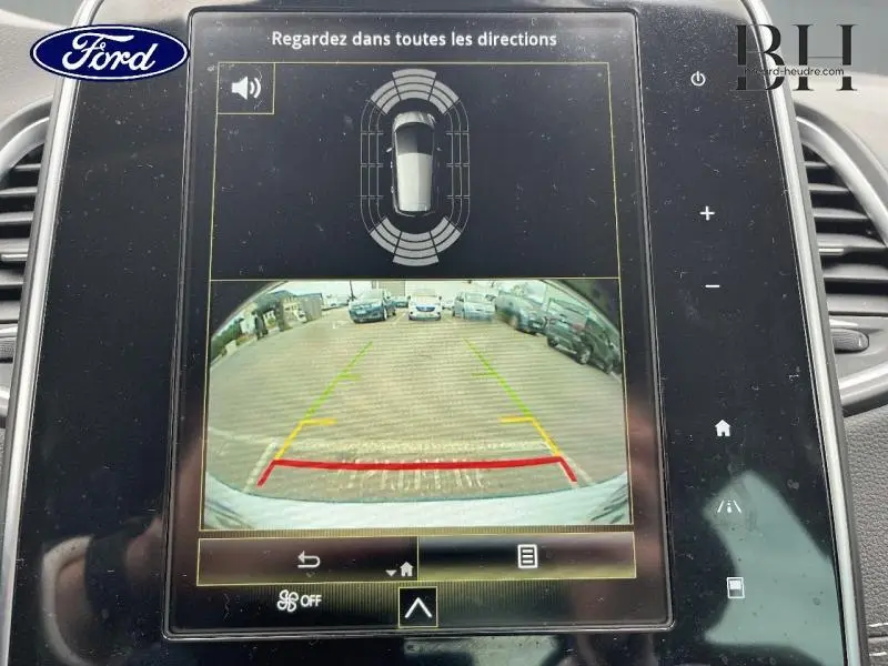 Affichage de la caméra de recul et des capteurs de stationnement sur l'écran tactile d'une Renault Scenic blanc nacré, vue intérieure.