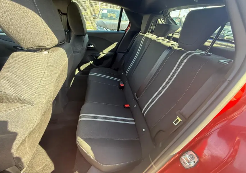 Vue intérieure côté droit sur les sièges arrière noirs avec bandes blanches d'une Opel Corsa rouge 2025.